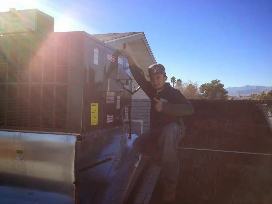 HVAC technician performing AC Tune-Up on a rooftop unit in Lawrence